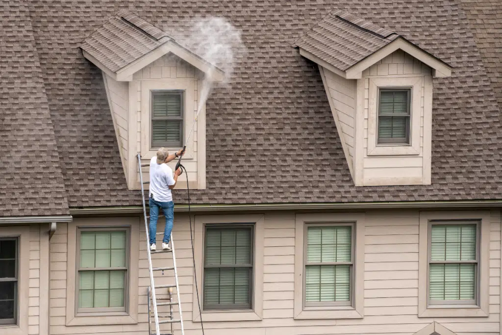 Man cleaning a house for pressure washing Lakeland
