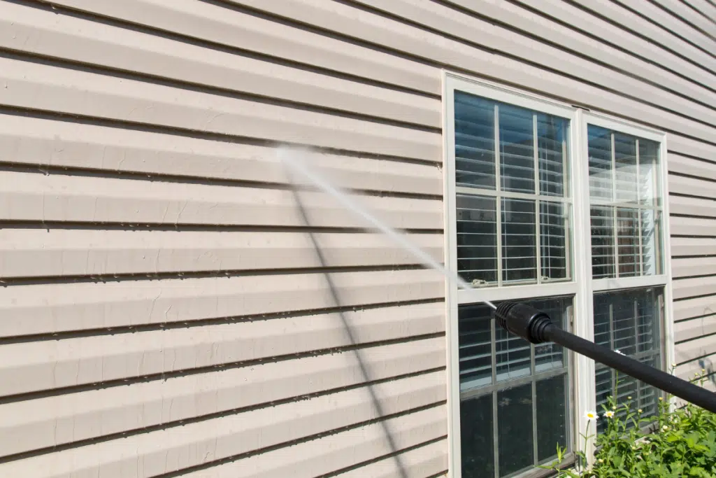 Professional pressure washing the siding of a house 