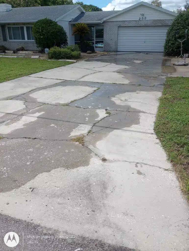 Cracked driveway leading to a garage