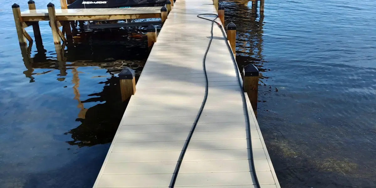 Wooden dock with hose over calm water